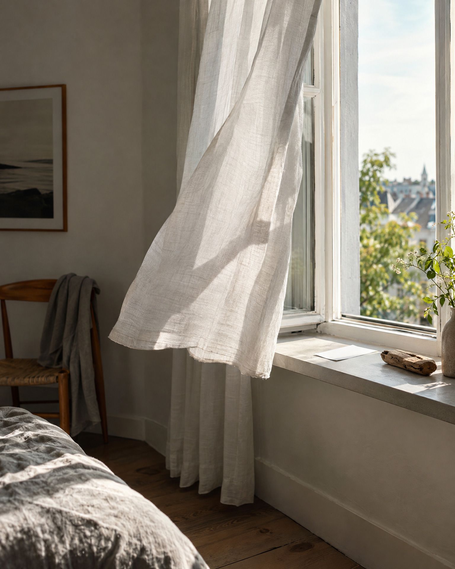 Ein geöffnetes Fenster mit wehendem Vorhang. Auf der Fensterbank liegen ein unbeschrifteter Zettel und ein kleines Holzstück.